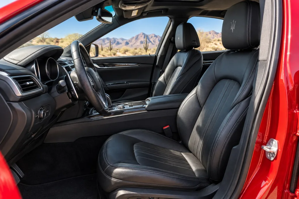 Illustration: Clean black leather seats and center console framed by an open red car door
